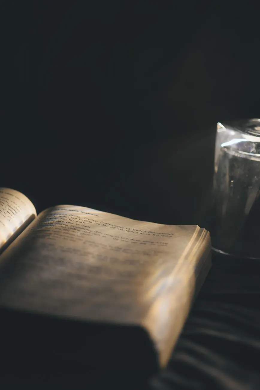 Libro abierto sobre una superficie oscura, iluminado por una luz cálida y suave